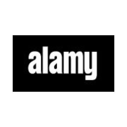 Alamy: Disabled schoolboy reading book in library at school